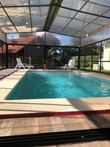a pool with a pool table and chairs in it at Hotel Termal Dayman in Termas del Daymán