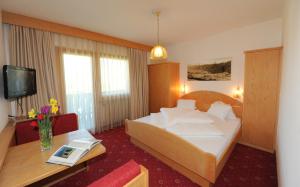 ein Hotelzimmer mit einem großen Bett und einem Tisch in der Unterkunft Gasthof Stern in Prad am Stilfserjoch