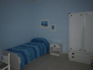 Habitación azul con cama y mesita de noche en AL 4 della Pergola, en Cavo