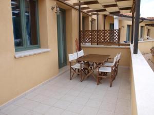 a patio with a wooden table and chairs on a house at AL 4 della Pergola in Cavo