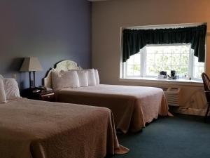 Inn at Amish Door في Wilmot: غرفة فندقية بسريرين ونافذة
