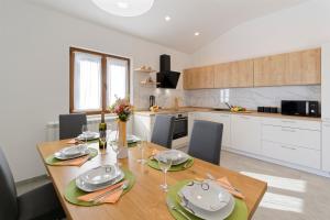 - une cuisine avec une table en bois, des assiettes et des verres à vin dans l'établissement Villa Sonce, à Buzet