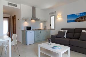 un soggiorno con divano e tavolo di Apartamentos Proa - Emar Hotels Only Adults a Es Pujols