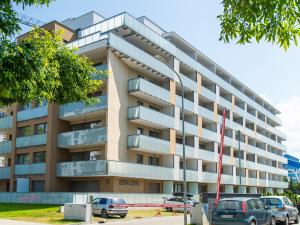 apartamentowiec z samochodami zaparkowanymi przed nim w obiekcie BellMi Apartamenty - Parking Gratis, Plaża 5min, Komfort i Relaks w Kołobrzegu