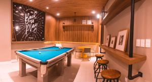 una sala de billar con mesa de billar y taburetes en Malibu Plaza Hotel en Lauro de Freitas