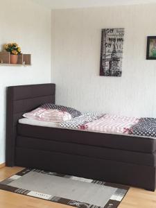 Cette chambre comprend un lit avec un cadre noir. dans l'établissement Ferienwohnung- Helena, à Schwerte