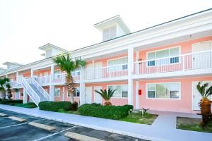 Tropical Isle #205 في شاطئ فورت والتون: عمارة سكنية فيها نخيل في موقف للسيارات
