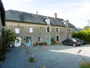 a stone house with a car parked in front of it at La Bicyclette Bleue in Montpinchon