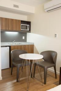 a kitchen with two chairs and a white table at Way Apartamentos in Montevideo