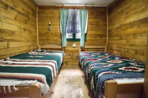 two beds in a room with wooden walls at Vajat Tuk in Bajina Bašta