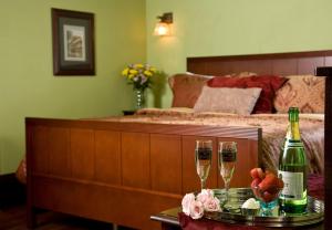 a bedroom with a bed and two glasses of champagne at Hilltop Manor B&B in Hot Springs