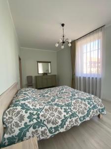 um quarto com uma cama com um cobertor azul e branco em Radis em Klaipėda