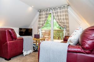 sala de estar con muebles de color rojo y ventana grande en 12 Valley Lodge en Gunnislake