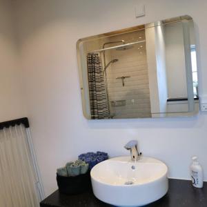a bathroom with a white sink and a mirror at Samsø værelseudlejning in Tranebjerg