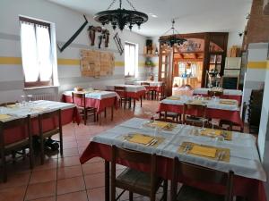 ein Restaurant mit Tischen und roten und weißen Tischdecken in der Unterkunft Agriturismo La Ruota in Montelupo Albese
