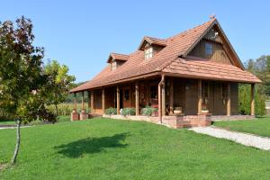 una casa grande con techo en un césped verde en Old Oak House with pool, en Maruševec