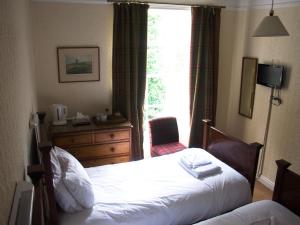 a bedroom with a bed and a dresser and a window at Horseshoe Hotel in Whitby