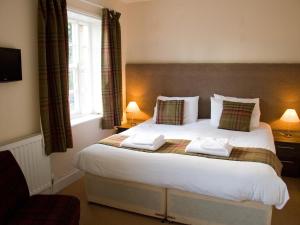 a bedroom with a large bed with two pillows at Horseshoe Hotel in Whitby
