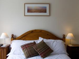 a bed with two pillows on it with two lamps at Horseshoe Hotel in Whitby