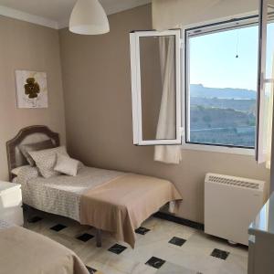 Schlafzimmer mit einem Bett und einem Fenster in der Unterkunft Casa escarpes de Trejo in Setenil de las Bodegas