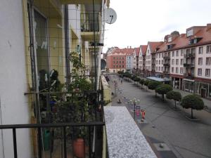 een balkon met uitzicht op een straat met gebouwen bij Apartament Wrocław przy Rynku in Wrocław
