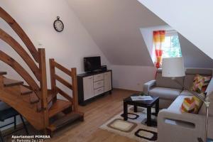 ein Wohnzimmer mit einer Treppe und einer Couch in der Unterkunft Apartament Poręba, dwupoziomowy, 8-osobowy in Szklarska Poręba