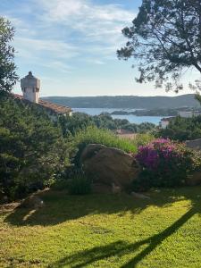 un giardino con roccia e un faro sullo sfondo di Residence Gli Oleandri 128 - Costa Smeralda - Porto Cervo a Porto Cervo
