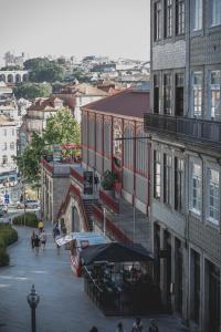 eine Stadtstraße mit Gebäuden und Menschen, die auf der Straße spazieren in der Unterkunft viterbo'8 - The Artists House in Porto