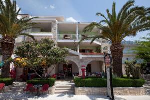 a hotel with palm trees in front of it at Apartments Milana in Tučepi
