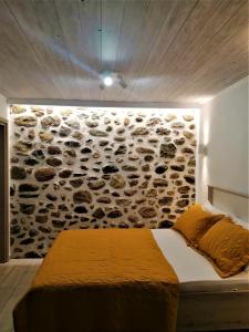a bedroom with a stone wall with a bed at The Little Gem Under The Rocks 2 in Kastraki