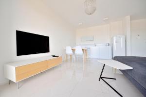 a living room with a flat screen tv on a white wall at City Center Aupark Apartment in Piešťany