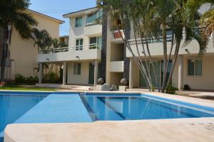 a swimming pool in front of a building at Zenharmony Suites in Puerto Vallarta
