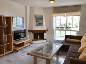ein Wohnzimmer mit einer Couch und einem Couchtisch in der Unterkunft El Cortijuelo. Magnificent triplex terraced house with rooftop of 18m2, overlooking the sea. Parking in Torremolinos