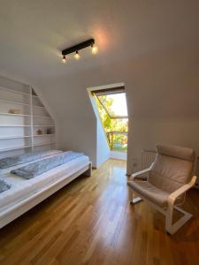 una camera da letto con un letto, una sedia e una finestra di Ferienwohnung Albrecht a Wilhelmshaven