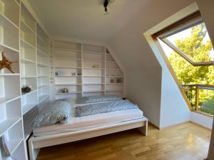 1 dormitorio con estantes blancos y 1 cama con ventana en Ferienwohnung Albrecht, en Wilhelmshaven