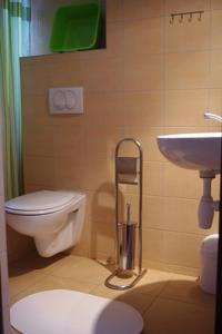 a bathroom with a toilet and a sink and a toilet istg at Apartamenty i pokoje Skrzypkowscy.pl in Karwia
