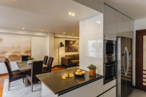 een keuken en een woonkamer met een tafel en een koelkast bij ESM Rental - Bombarda's Premium Terrace in Porto