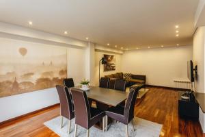 een eetkamer met een tafel en stoelen en een bank bij ESM Rental - Bombarda's Premium Terrace in Porto