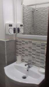 y baño con lavabo blanco y espejo. en B&B FRANCESCA en Santa Maria di Castellabate