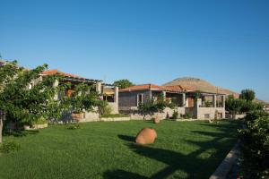 a house with a large yard with a ball on the grass at Filia Villas in Mirina