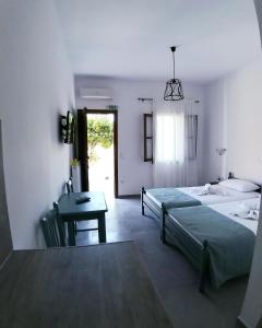 1 dormitorio con 2 camas, mesa y escritorio en Mavrikou Helen Apartments, en Skiros