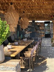 a restaurant with a long wooden table and chairs at Harmony Luxury Villas Naxos in Naxos Chora