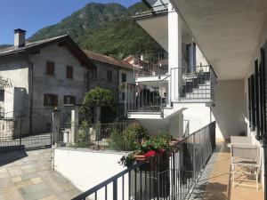 un balcón de una casa con escaleras y flores en Nel cuore dell'Ossola, en Pallanzeno