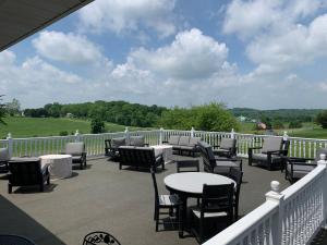 a patio with tables and chairs on a balcony at Inn at Amish Door in Wilmot