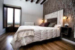 - une chambre avec un grand lit et un mur en briques dans l'établissement RIOJAVALLEY Apartamentos, à Cenicero
