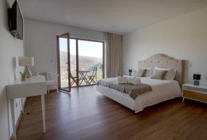 a bedroom with a bed and a desk and a window at Vila Douro Guesthouse in Mesão Frio +23 photos