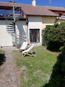 a pair of chairs sitting outside of a house at Pokoj hotelowy bis dwu osobowy in Łeba