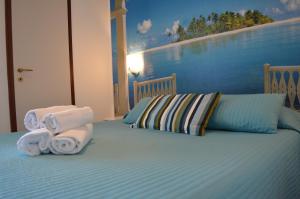 een slaapkamer met een bed met handdoeken erop bij Hotel Merano in Grado