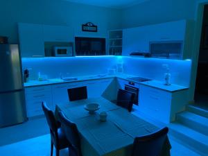 a kitchen with a dining table and a blue light at Apartments Vila Vino in Sveta Nedelja