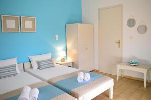 a bedroom with two beds and a blue wall at Sofia Kalyves in Kalyves